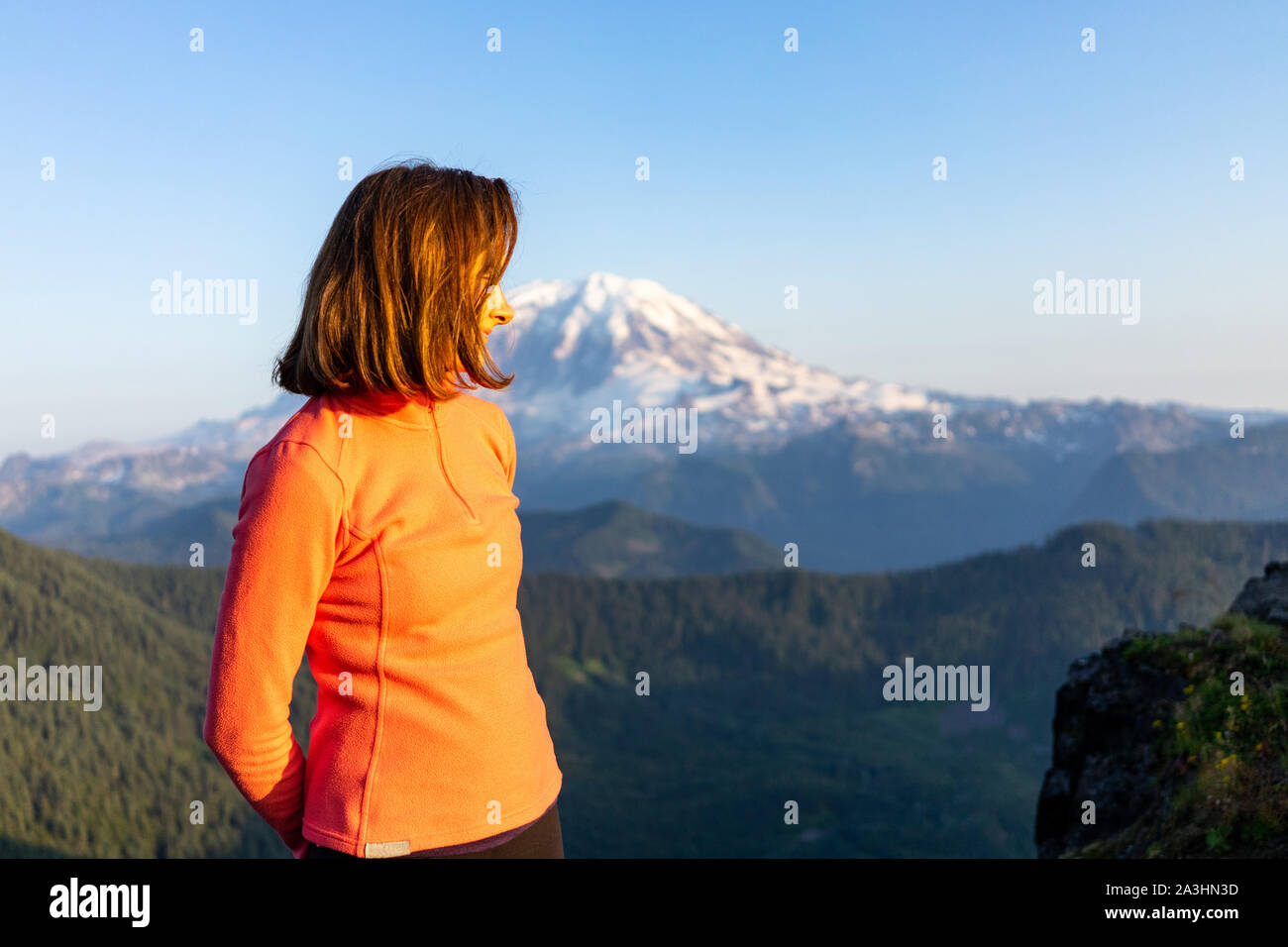 Woman hiker is loving the sunset at mount Rainier National Park, Wash Stock Photo