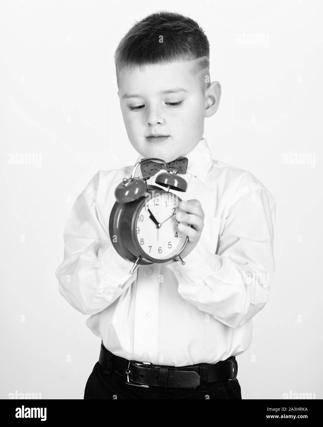 tuxedo kid. Happy childhood. Party time. Businessman. Formal wear. Time management. Morning. little boy with alarm clock. Time to relax. happy child with retro clock in bow tie. what time is it. Stock Photo