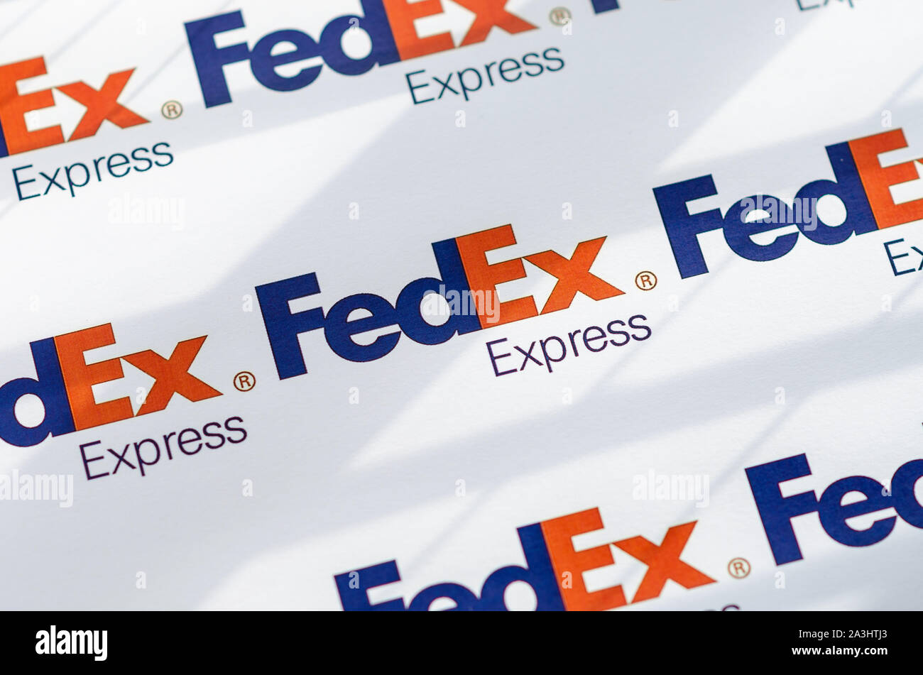 Multiple FedEX logos on a large canvas with the natural sunlight falling on it.  The shallow depth of field is used. Stock Photo