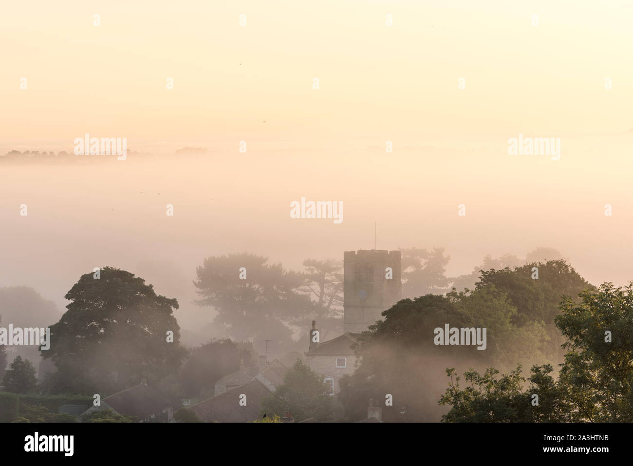 Dawn mist over Well in North Yorkshire. Stock Photo