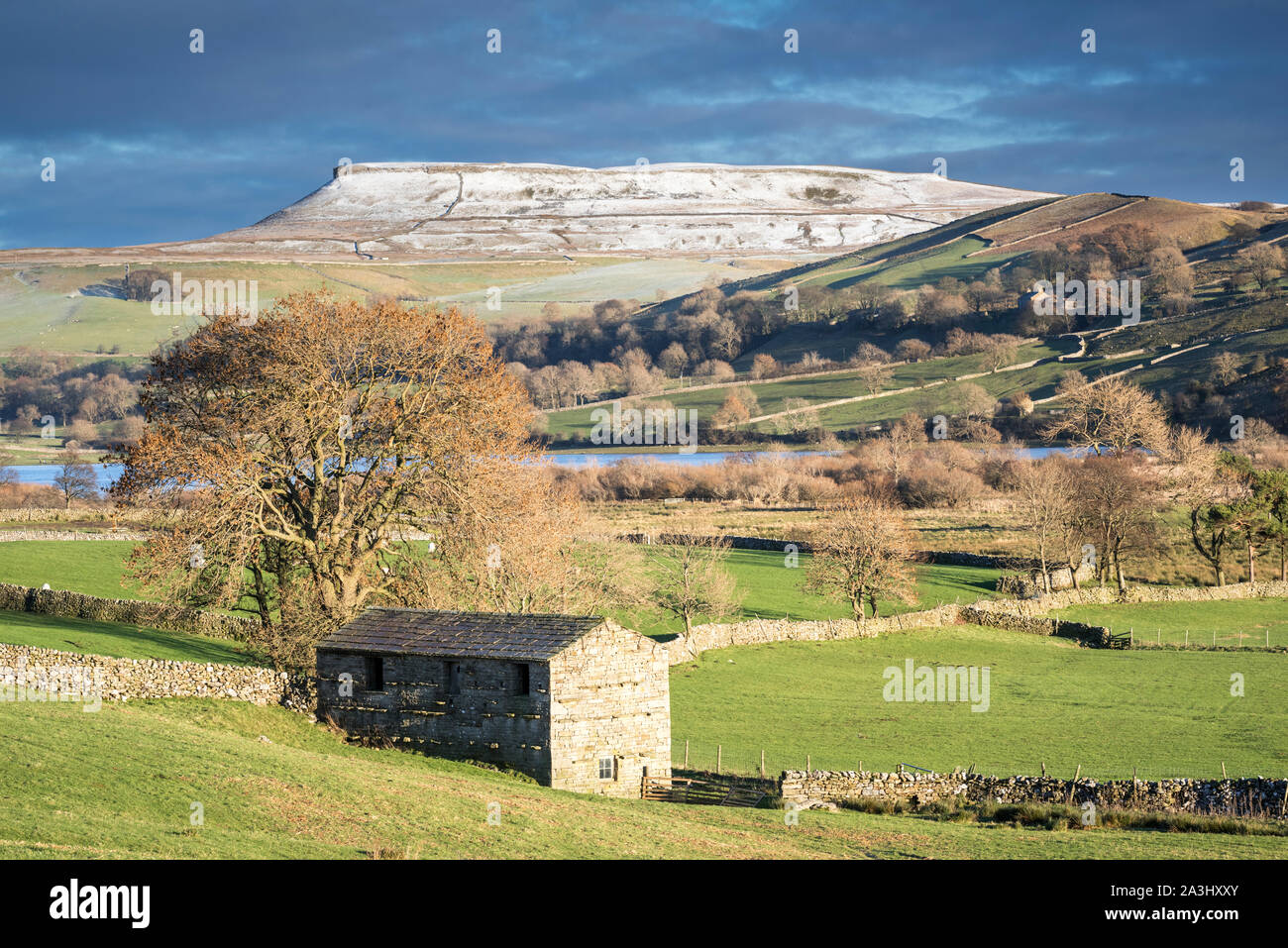 View across Raydale and Semer water towards the snow capped Addlebrough near Hawes, North Yorkshire. Stock Photo