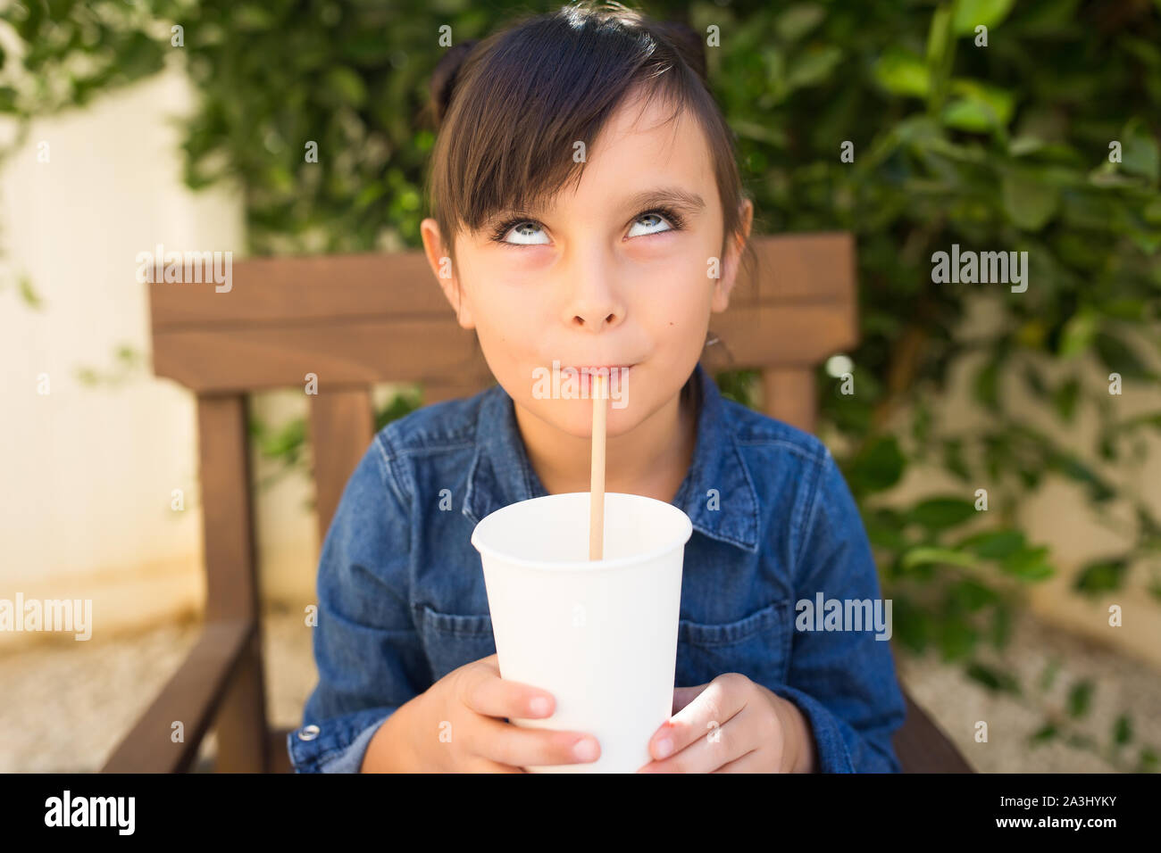 Girl making a face expression while drinking Stock Photo