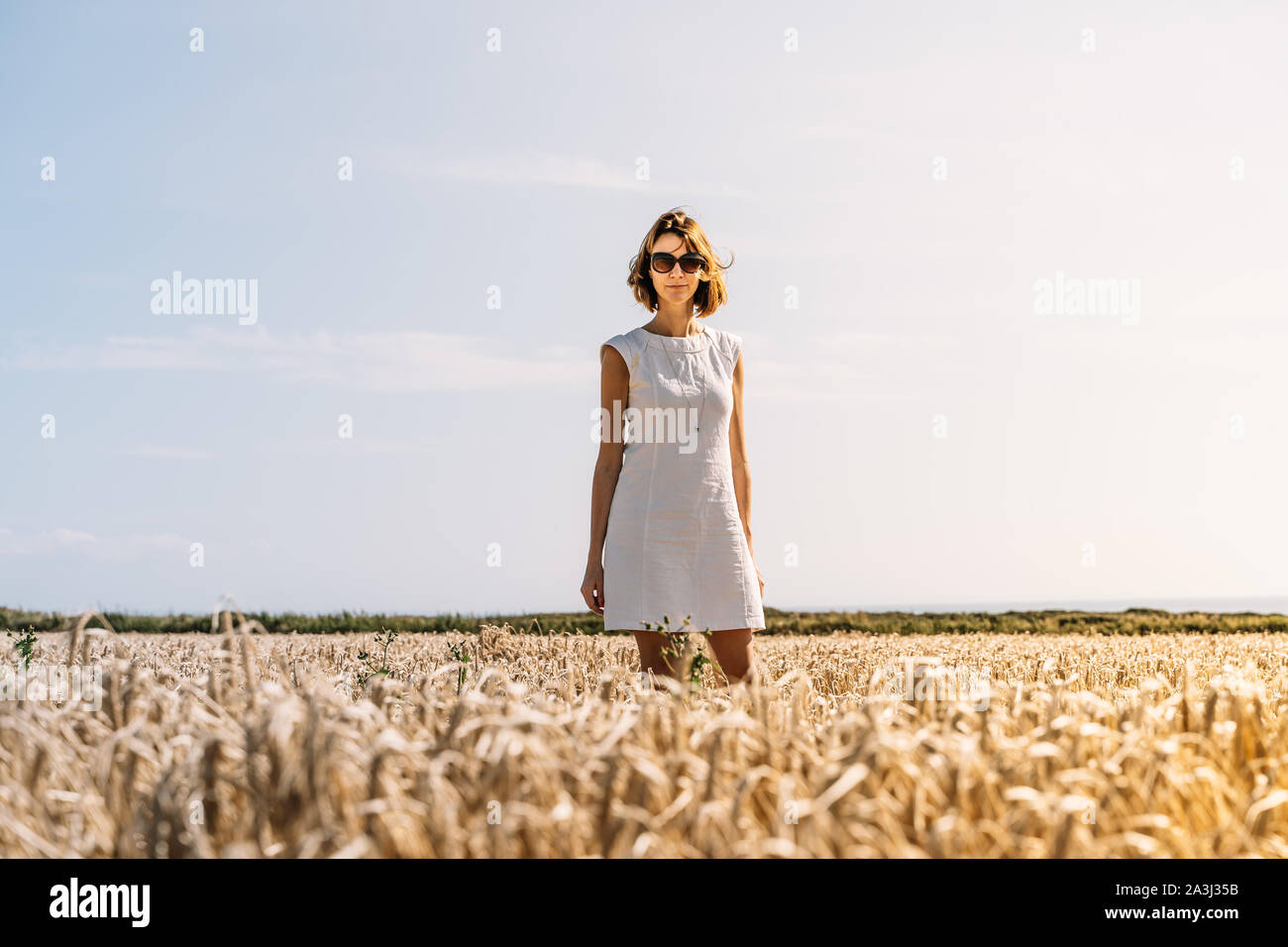 Portrait of woman in a beautiful white dress standing in the golden ...