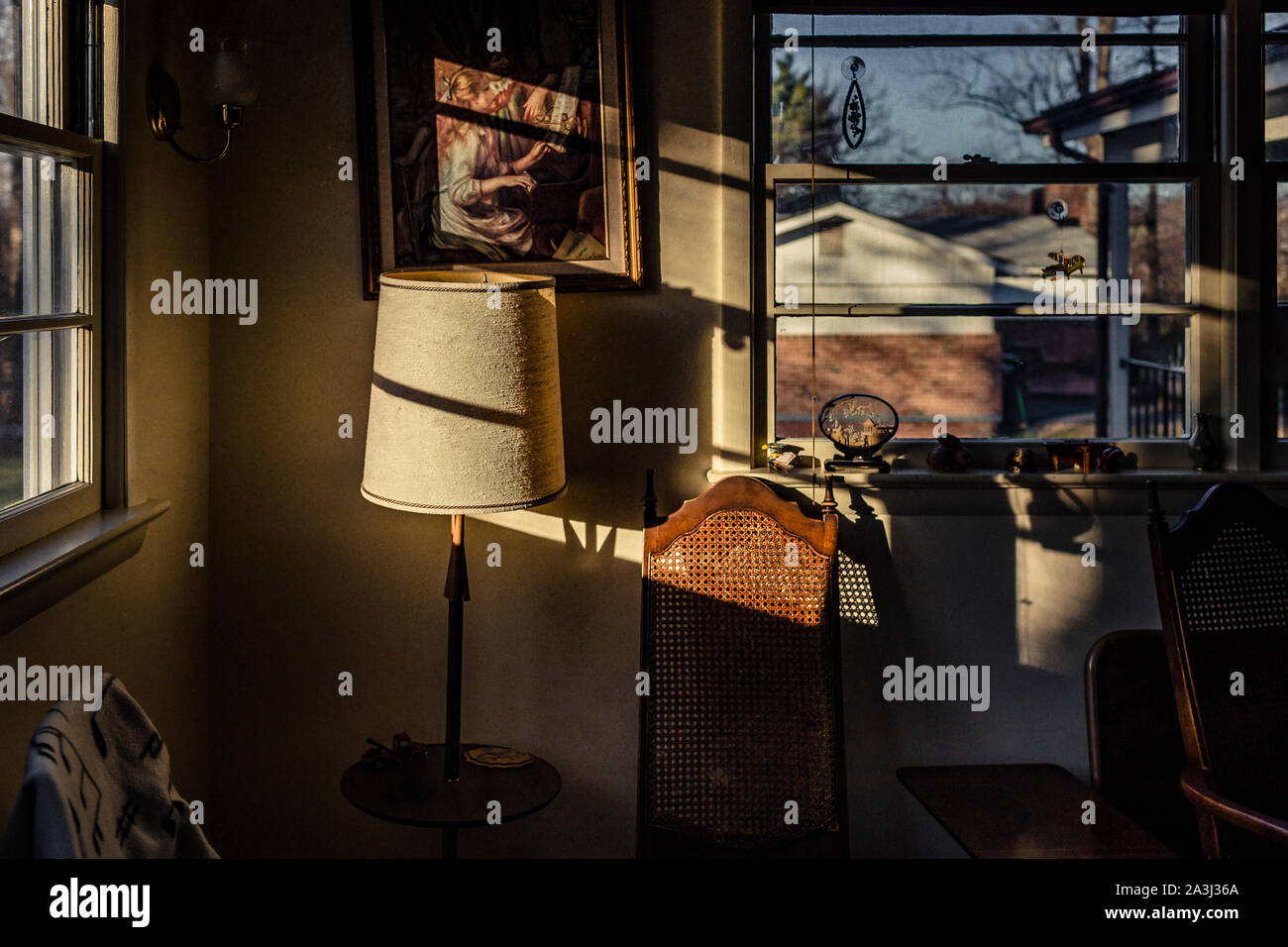 Afternoon sun casts harsh shadows in cluttered room Stock Photo