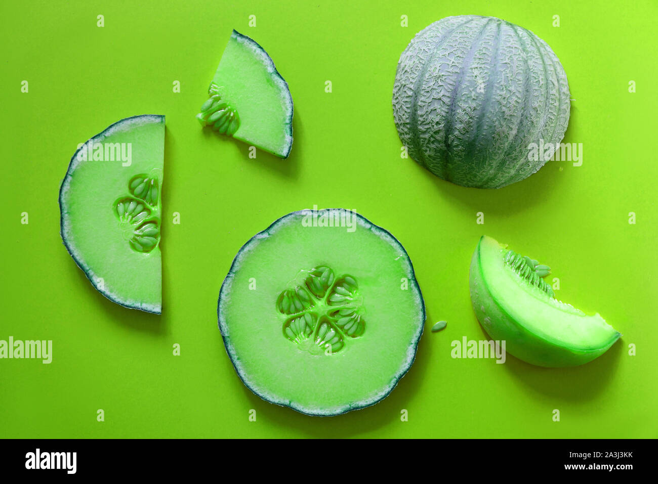 Slices cantaloupe sliced isolated on green neon background.Flat lay.concept food ideas Stock Photo