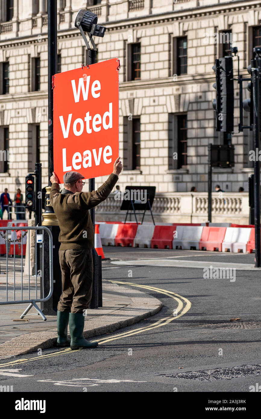 LONDON, UNITED KINGDOM - OCTOBER 1, 2019. Farmer is Holding the Red Banner on the Parliament Square Supporting Brexit - We Voted Leave. Stock Photo