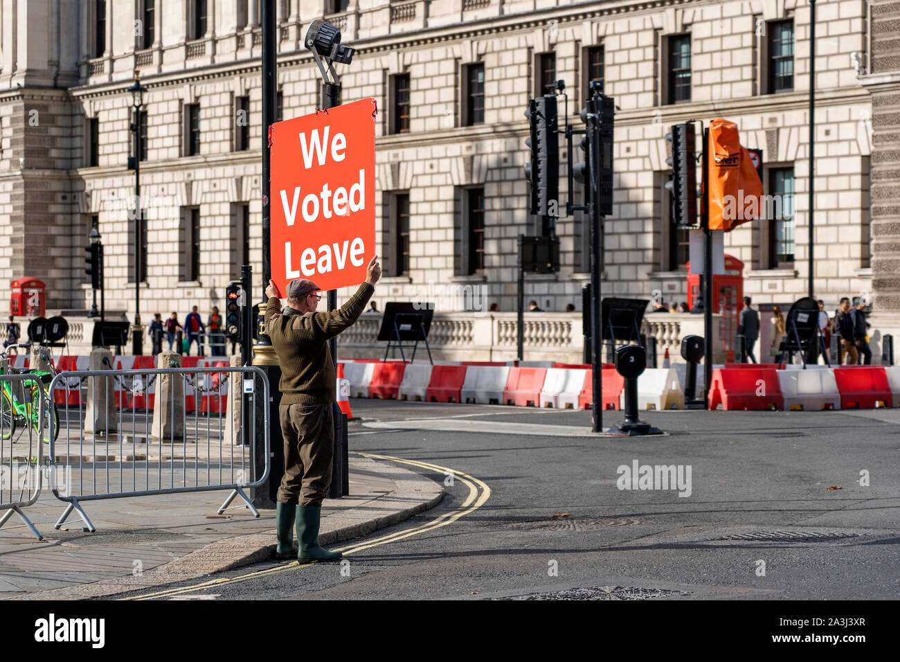 LONDON, UNITED KINGDOM - OCTOBER 1, 2019. Old Man is Holding the Red Banner on the Parliament Square - We Voted Leave. Stock Photo