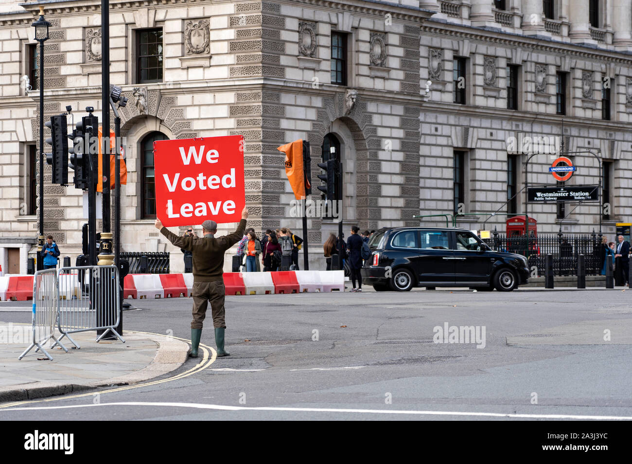 LONDON, UNITED KINGDOM - OCTOBER 1, 2019. Old Man is Holding the Red Banner on the Parliament Square Supporting Brexit - We Voted Leave. Stock Photo