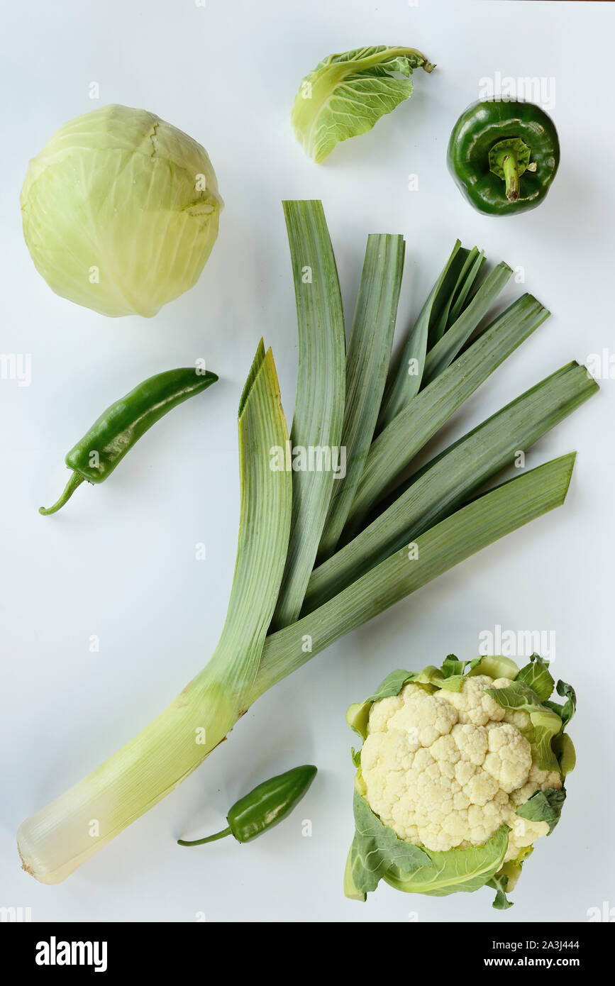 Creative layout made of white cabbage leek cauliflower green and chili pepper . Flat lay. Food concept. Green vegetables isolated on white background Stock Photo