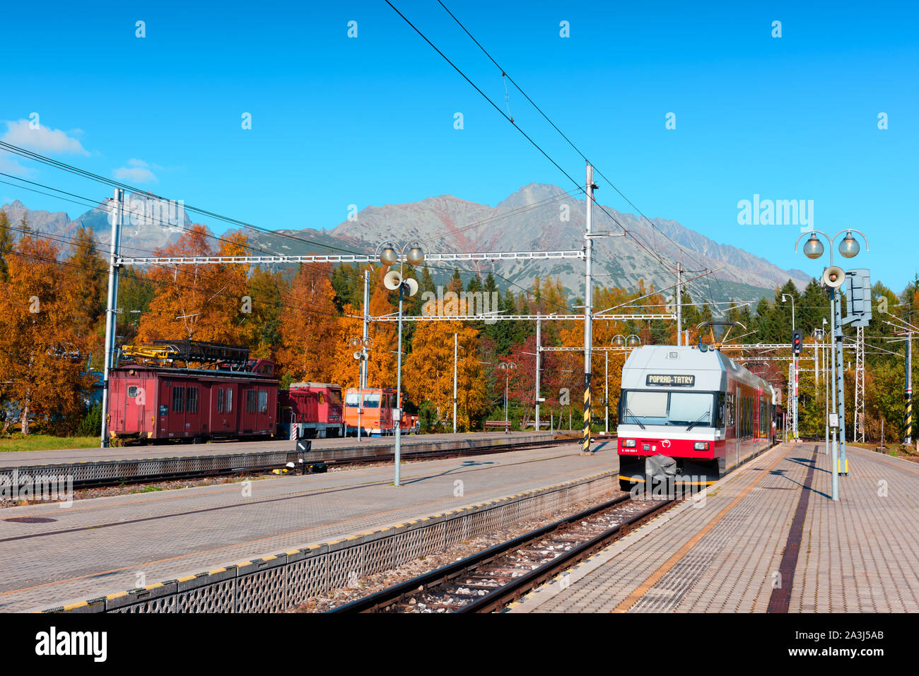 Arrival of the red train on Strbske pleso station in autumn Slovak Tatras Stock Photo
