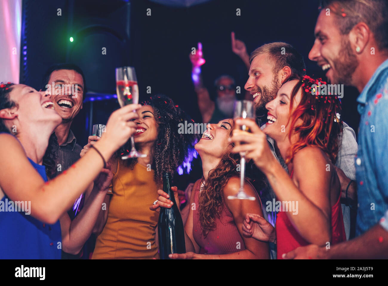 Group of friends dancing and drinking champagne at party