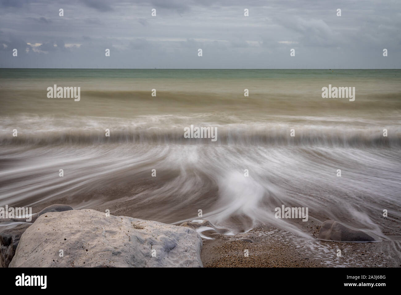 Retreating waves over shingle beach Stock Photo