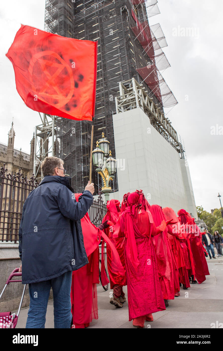 London, UK. 08th Oct, 2019. Environmentalist performance art troupe the 'Red Rebel Brigade' walk silently during the environmental protest by Extinction Rebellion activist group.Extinction Rebellion is an international movement that uses non-violent civil disobedience in an attempt to halt mass extinction and minimise the risk of social collapse. The group has blocked a number of key junctions in central London. Credit: SOPA Images Limited/Alamy Live News Stock Photo