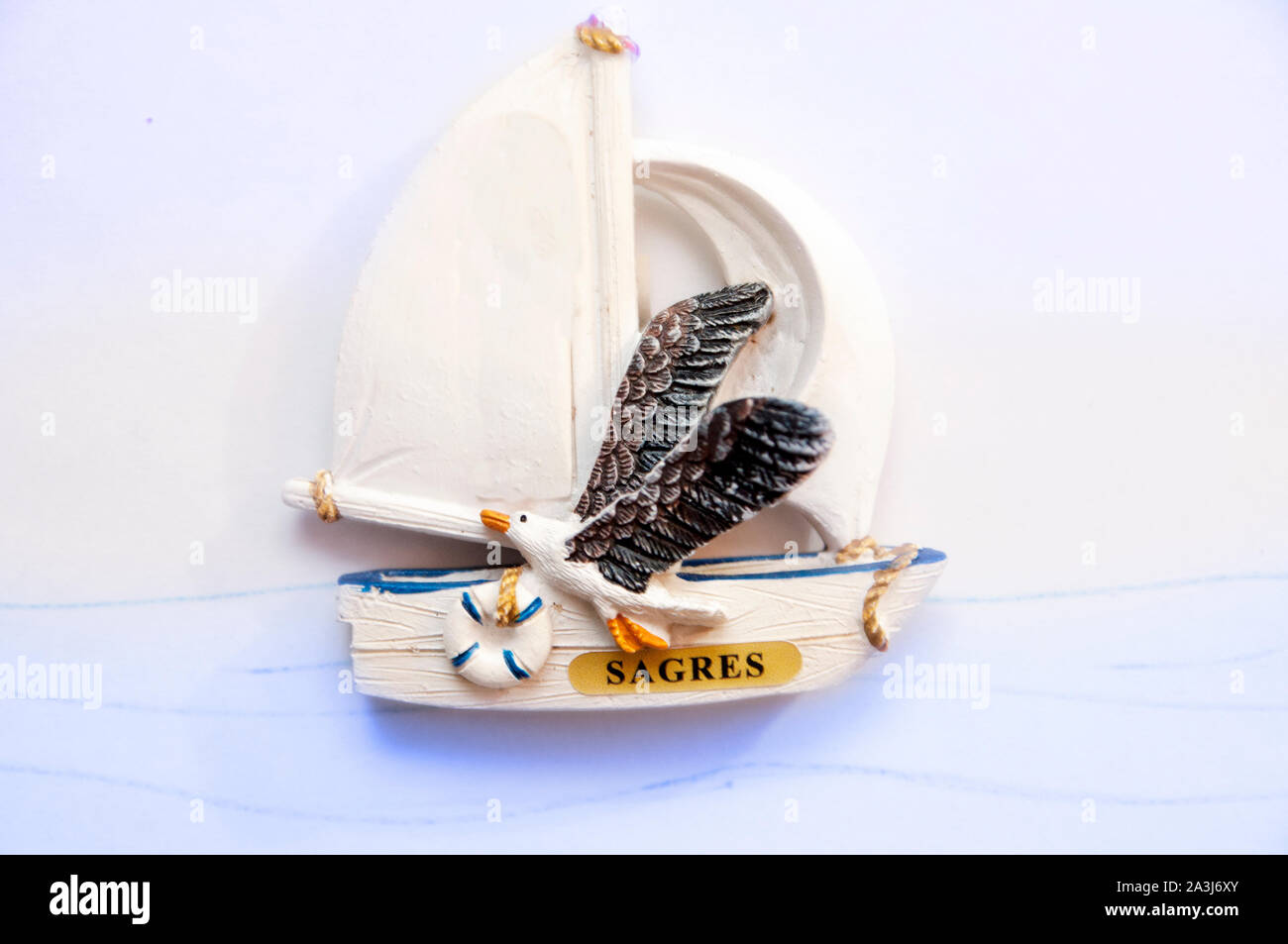 A ceramic souvenir of Sagre representing a sail boat with a seagull flying. Stock Photo