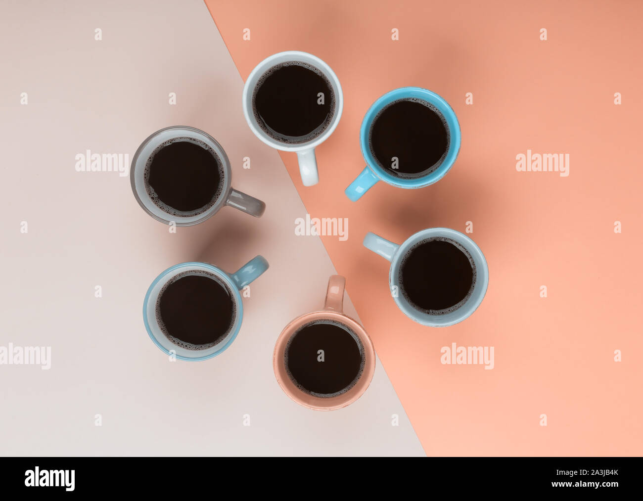 Americano in the different cups on the coral background. Flat Lay, cheerful day concept. This image could be used to show coffee break time or morning Stock Photo