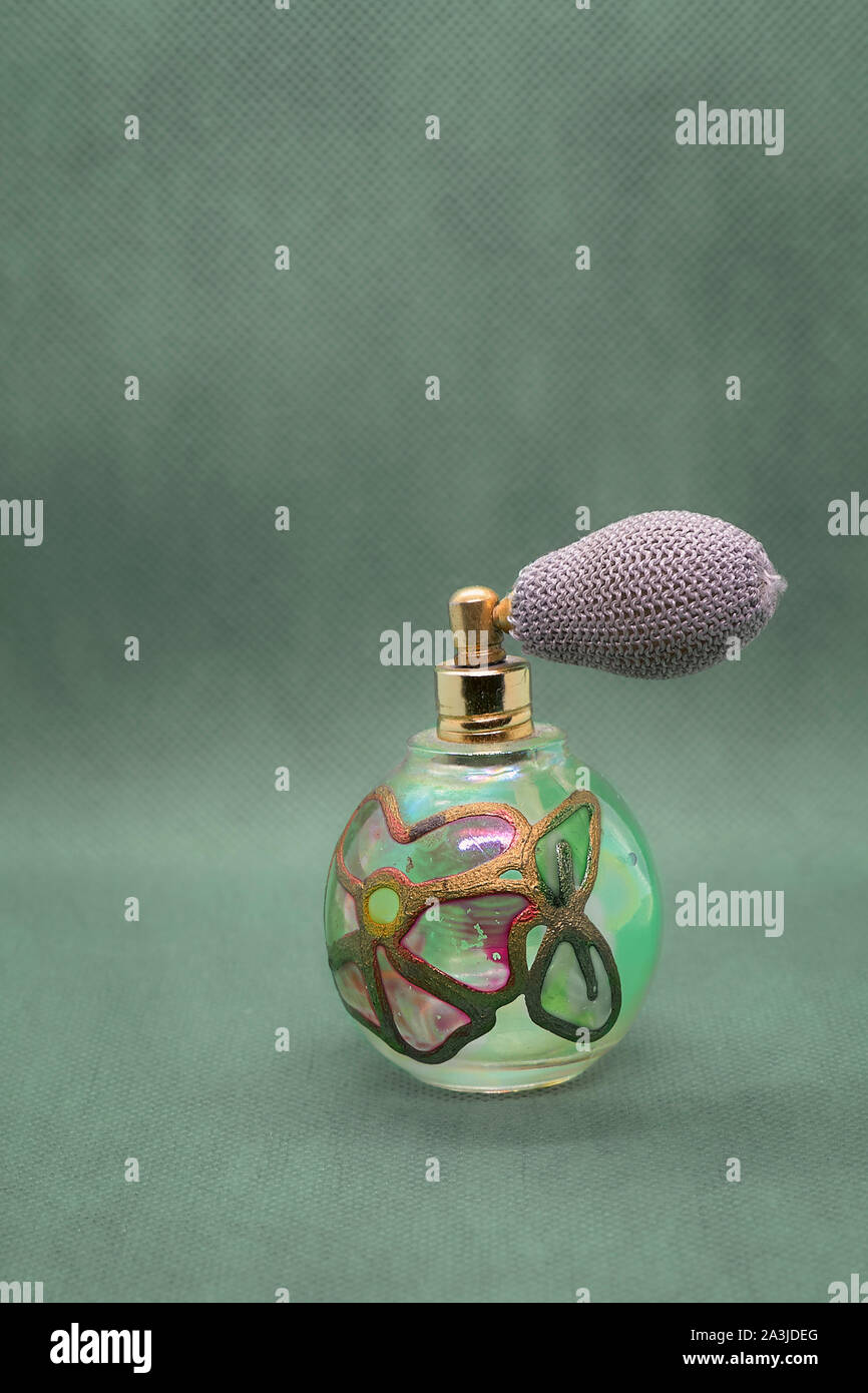 Antique atomizer for perfume dispensing on greenish gray background Stock Photo