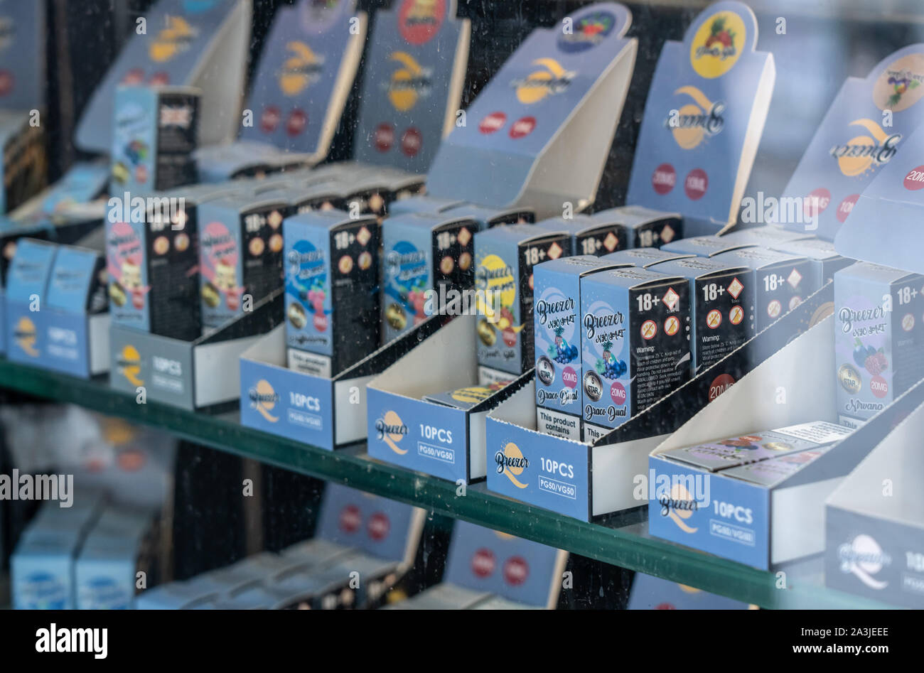 london-uk-4-october-2019-many-brands-of-flavored-nicotine-for-e-cigarettes-in-shop-with-reflection-of-street-in-window-2A3JEEE.jpg