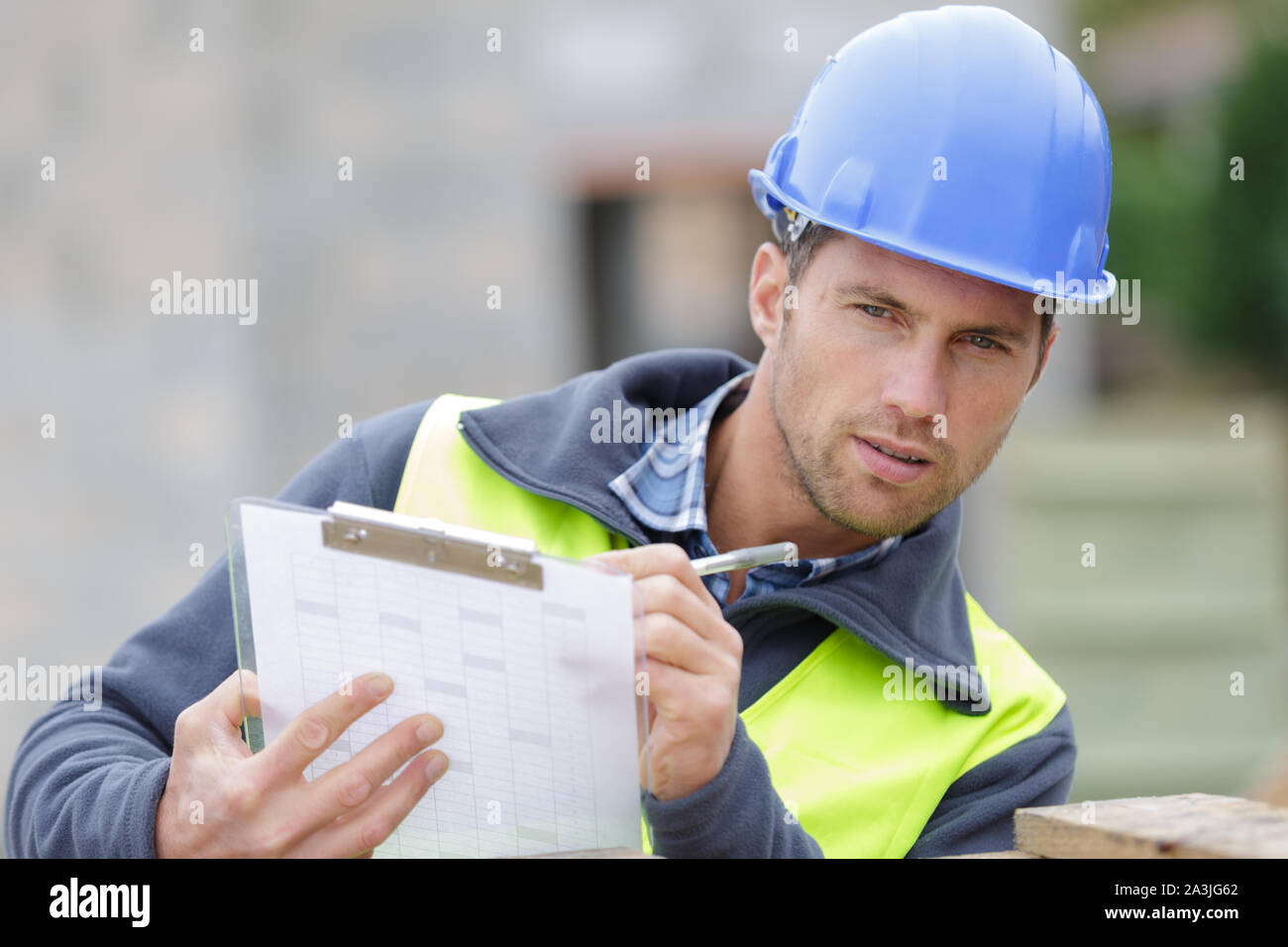 workman in blue dungarees with clipboard Stock Photo