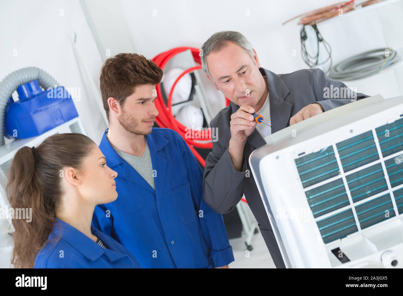 apprentices learning to repair industrial air conditioning Stock Photo