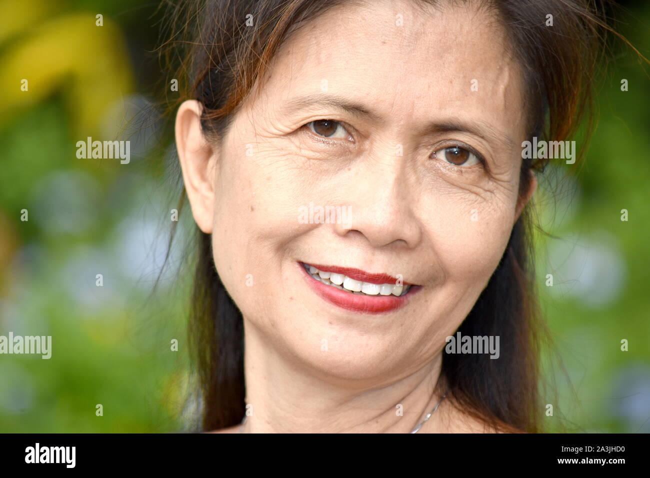 An Older Filipina Female Senior Smiling Stock Photo