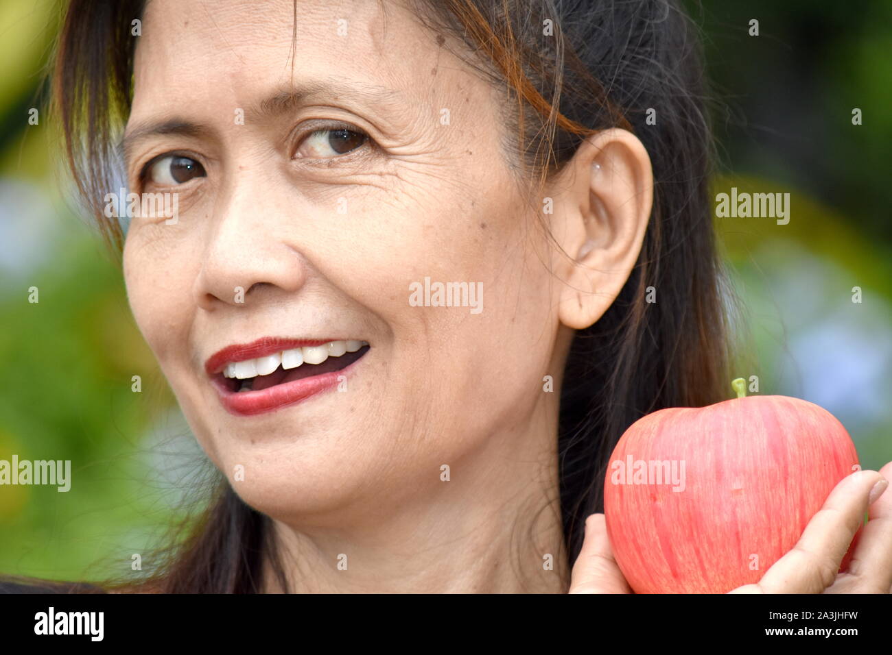 Smiling Retired Female Senior With Fruit Stock Photo