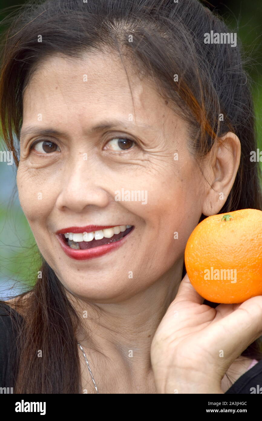 Smiling Filipina Female Senior With Fruit Stock Photo