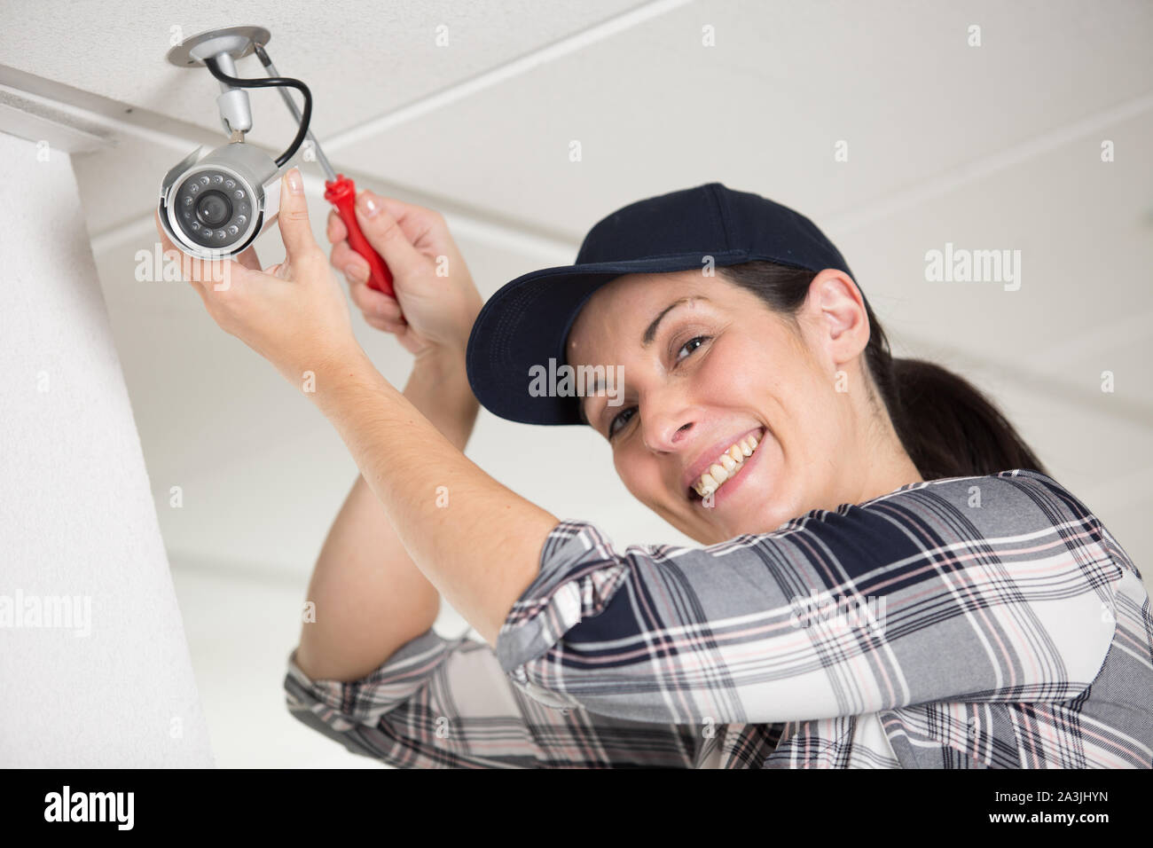 happy female technician fitting cctv camera Stock Photo