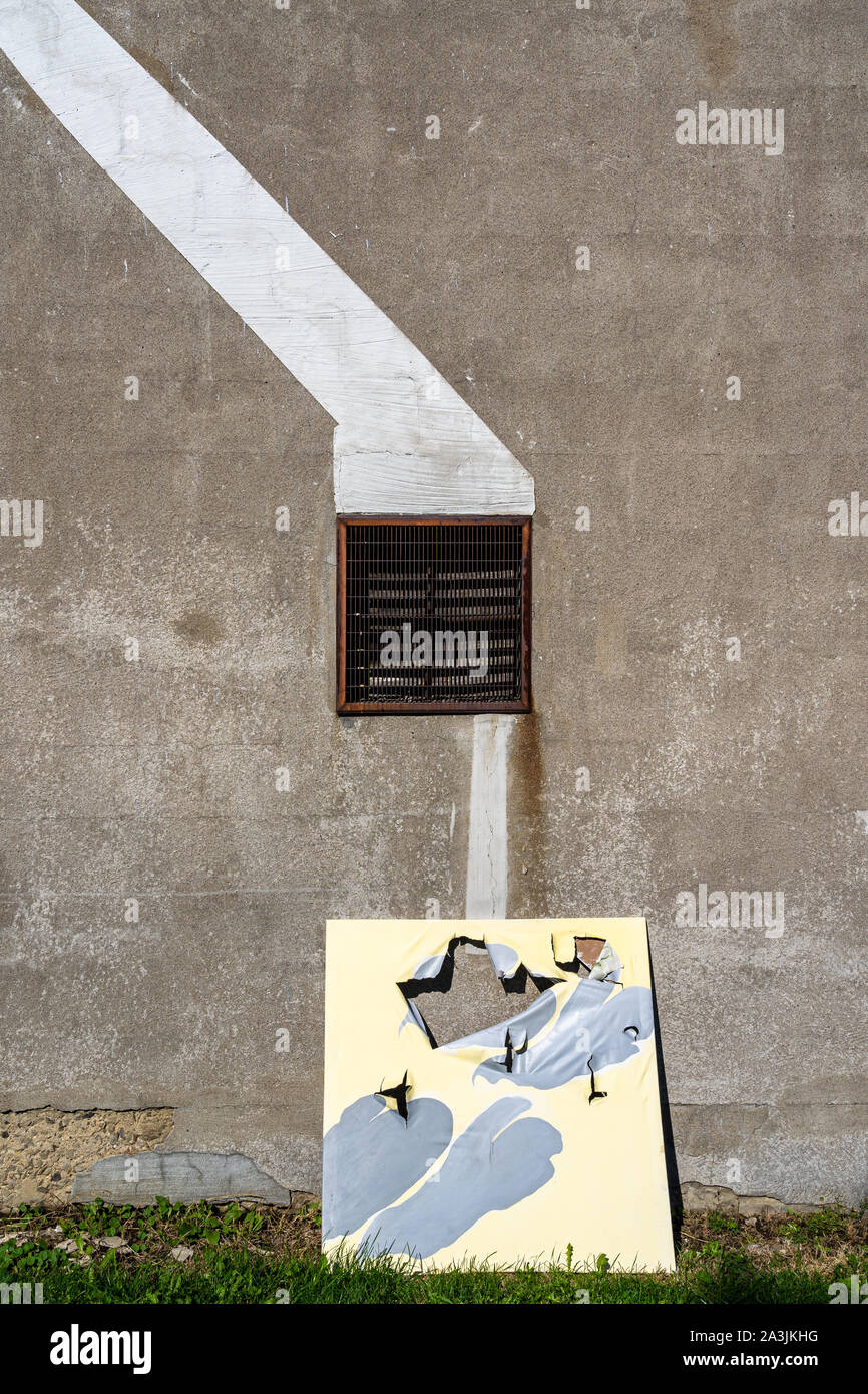 Painting against a cement wall with metal grate Stock Photo Alamy