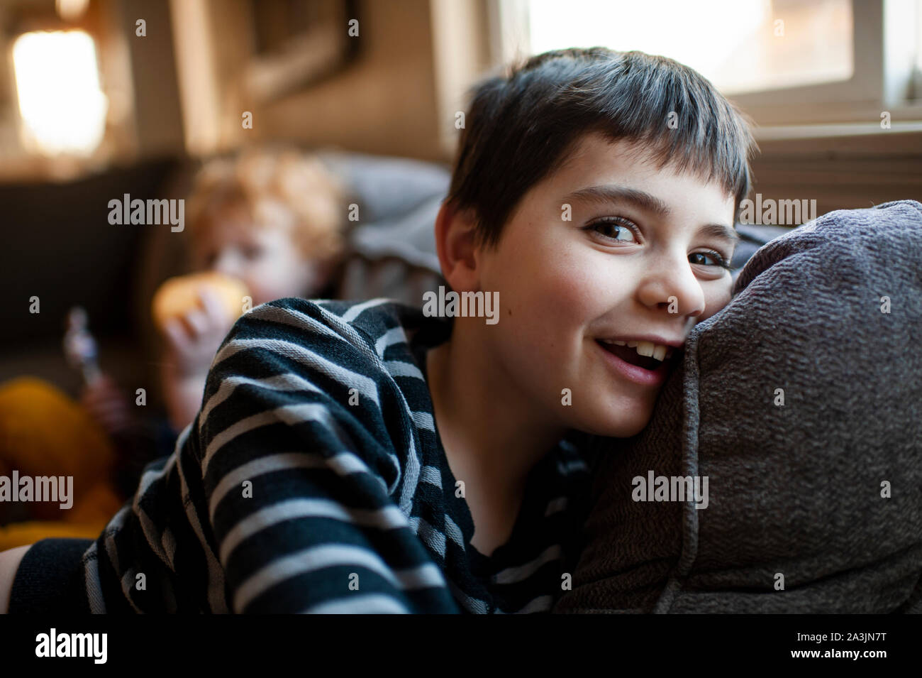 Happy 7 8 Year Old Boy Laying On Couch Smiling At Home Stock Photo Alamy