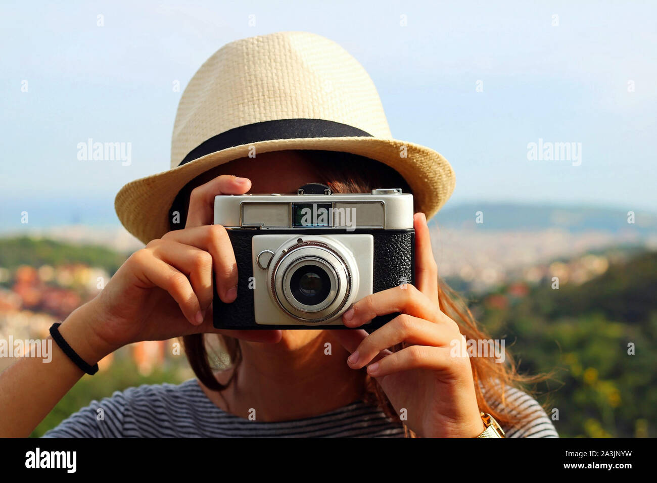 Young and beautiful girl taking pictures with an analog camera. Stock Photo