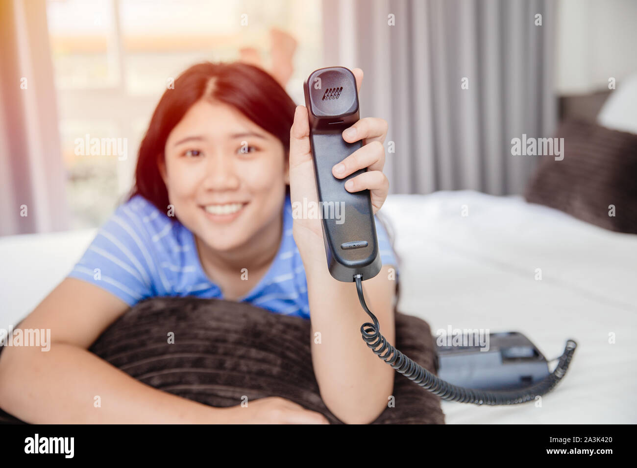 Asian girl teen with landline phone call happy smile impressive with customer care support concept. Stock Photo