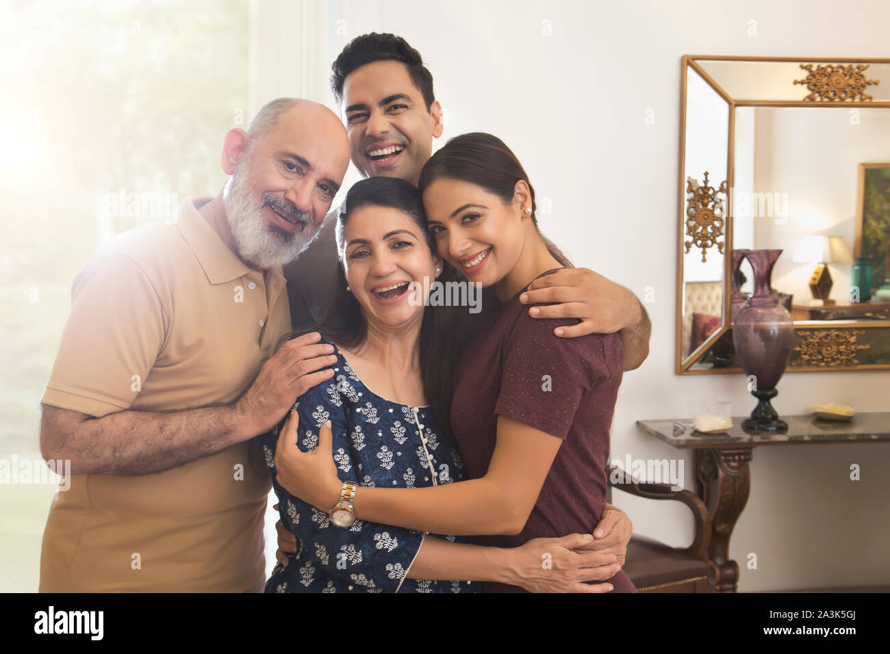 A family is standing close together in a group and smiling. Stock Photo