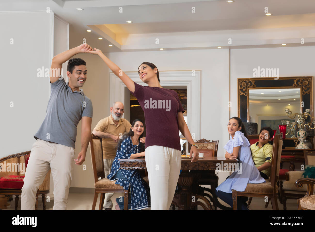 Young couple and senior couple standing in living room hires stock