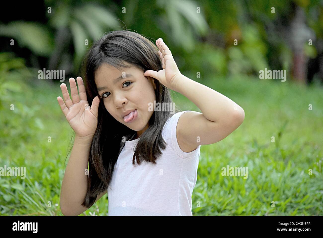 Young Asian Preteen Making Funny Faces Stock Photo