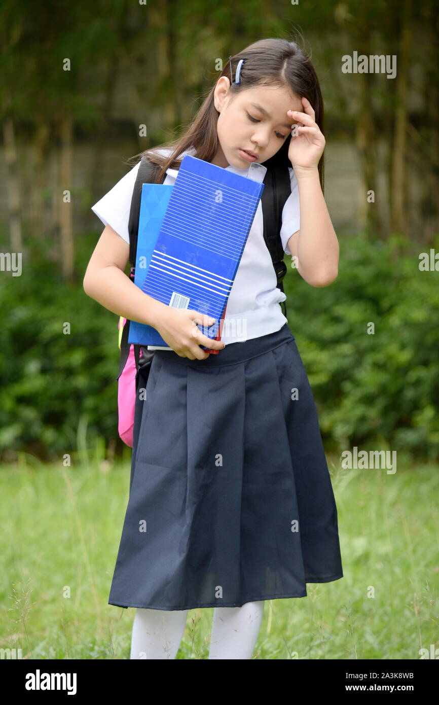 Depressed Female Student Wearing Uniform With Books Stock Photo