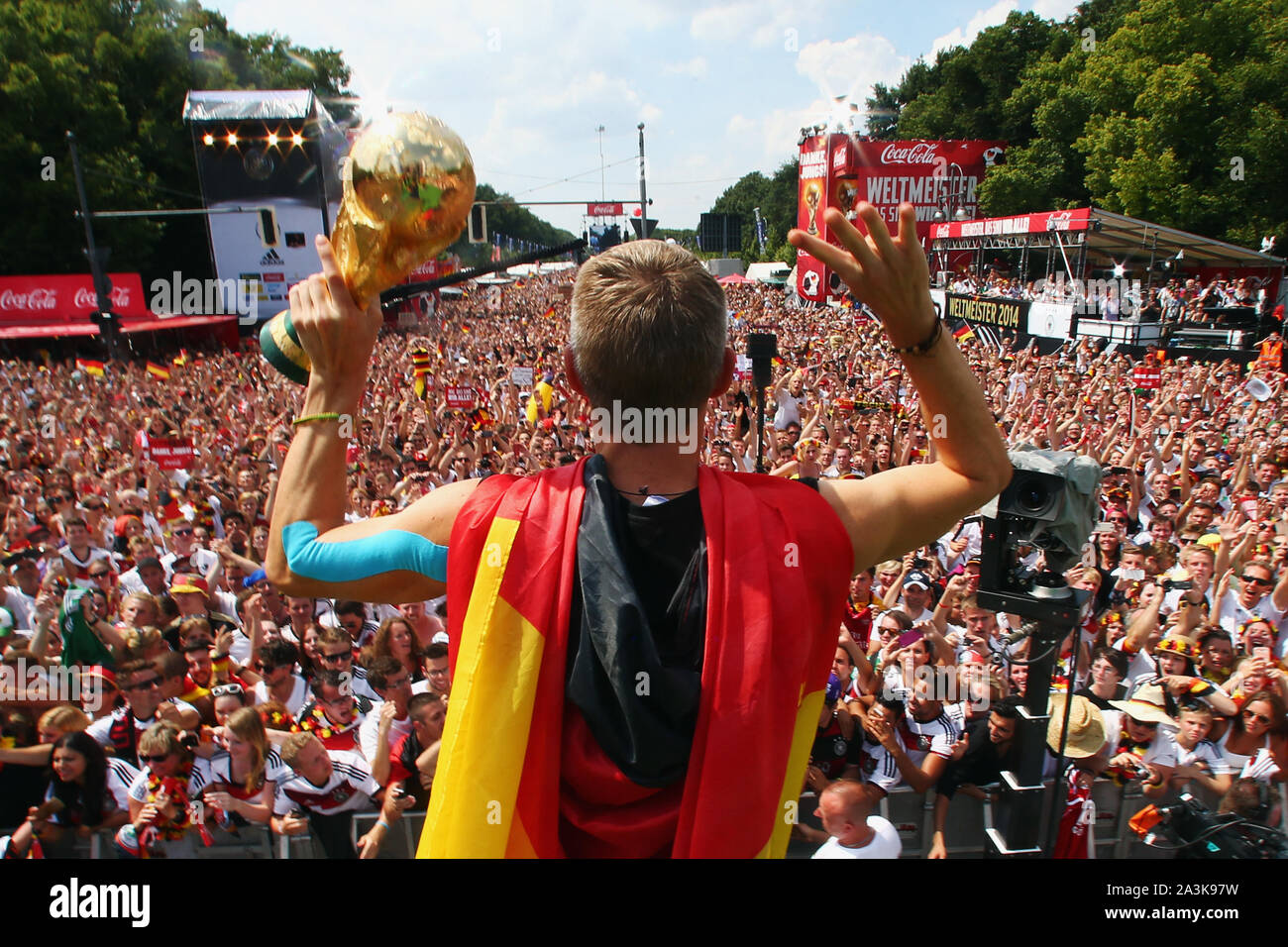 Bastian SCHWEINSTEIGER ends his career! Archive picture: Bastian SCHWEINSTEIGER (Germany) with World Cup trophy and Germany flag reception / World Cup party / ride on a truck / truck to celebrate the German national football team on the fan mile at the Brandenburg Gate in Berlin - reception of the German national football team in Berlin, DFB Party Feast of the World Champions on 15.07.2014 in Berlin, POOL PHOTO ¬ | usage worldwide Stock Photo