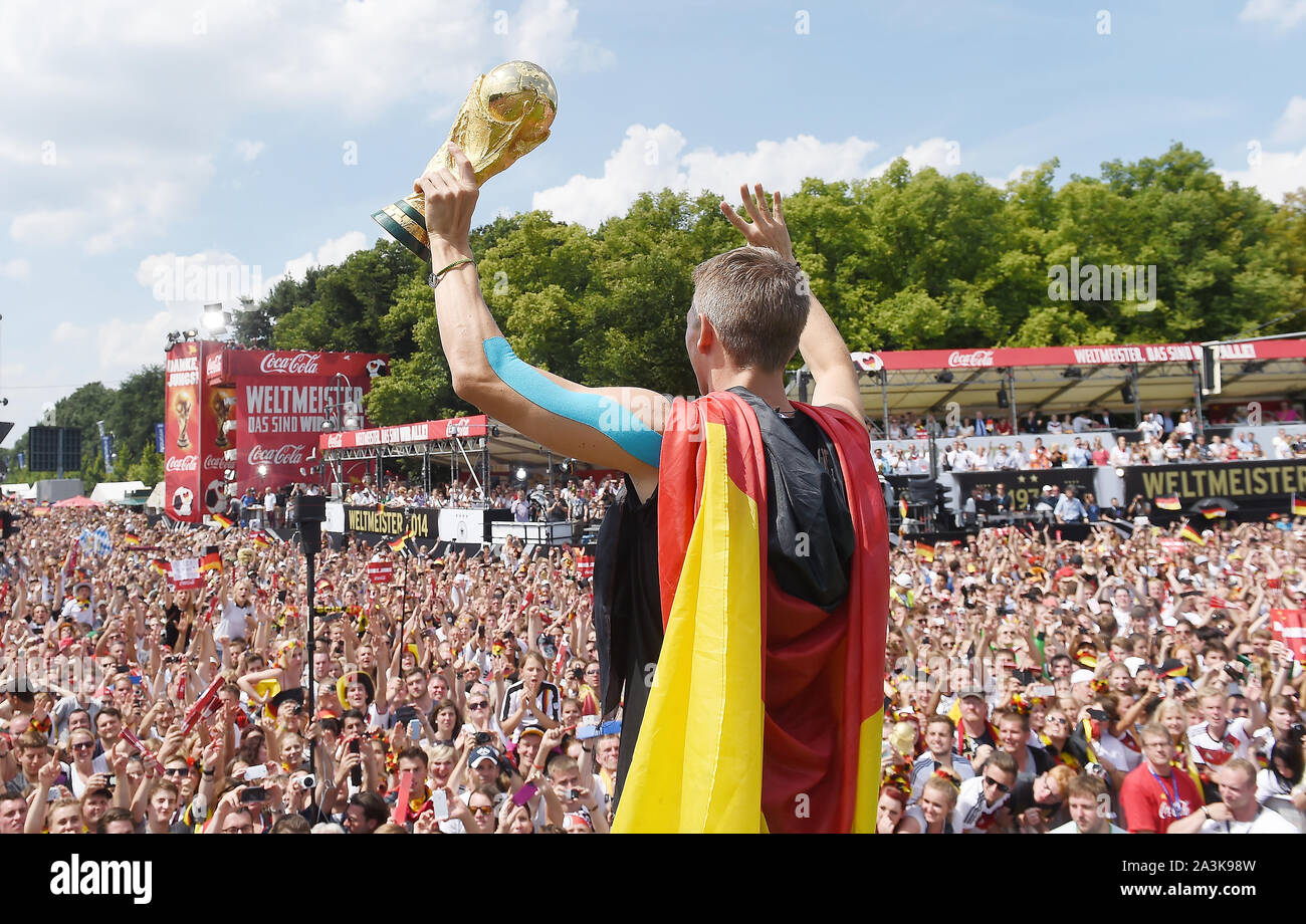 Bastian SCHWEINSTEIGER ends his career! Archive picture: Bastian SCHWEINSTEIGER (Germany) with World Cup trophy and Germany flag reception / World Cup party / ride on a truck / truck to celebrate the German national football team on the fan mile at the Brandenburg Gate in Berlin - reception of the German national football team in Berlin, DFB Party Feast of the World Champions on 15.07.2014 in Berlin, POOL PHOTO ¬ | usage worldwide Stock Photo
