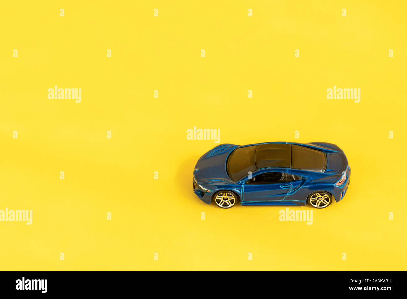 Moscow, Russia - 30 September, 2019. Blue kids toy car flat lay on colorful yellow background. Modern design. Minimal creative flatlay composition Stock Photo