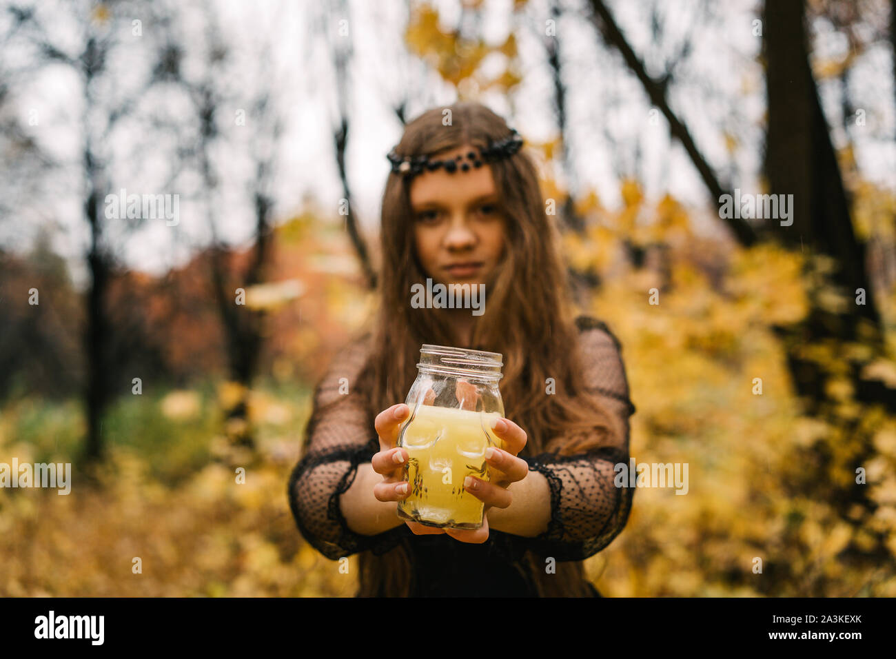 Pretty blonde girl in the autumn yellow fall park. Creative Halloween Day Stock Photo