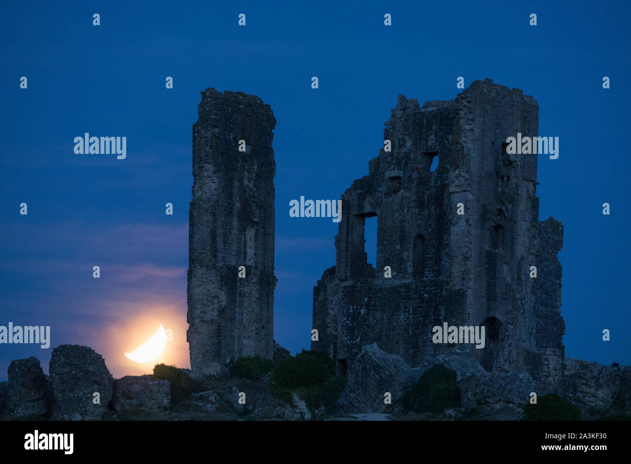 The partially eclipsed moon over Corfe Castle, Dorset, England, UK Stock Photo