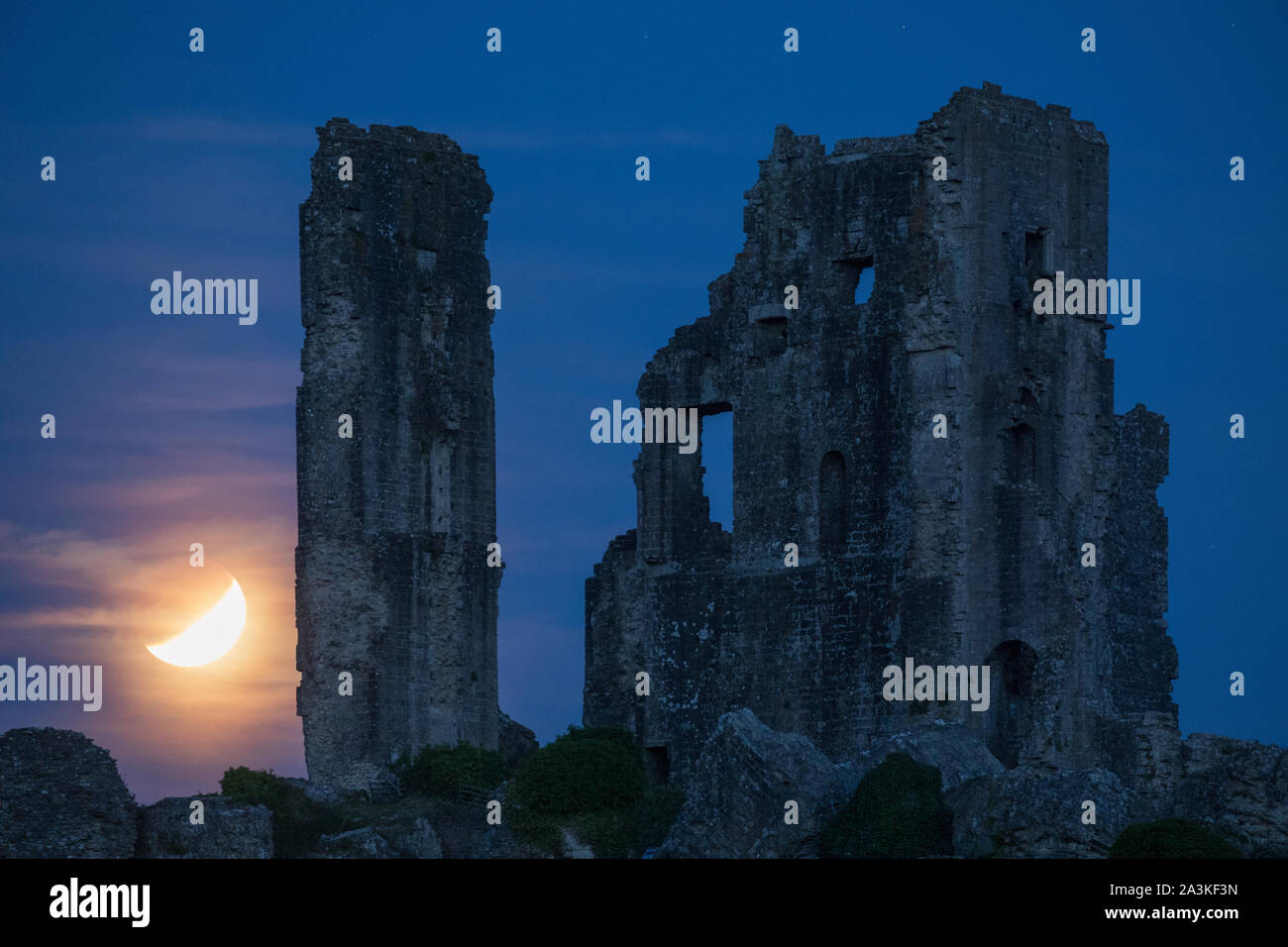 The partially eclipsed moon over Corfe Castle, Dorset, England, UK Stock Photo