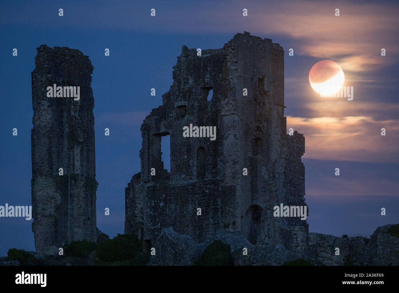the partially eclipsed moon over Corfe Castle, Dorset, England, UK Stock Photo