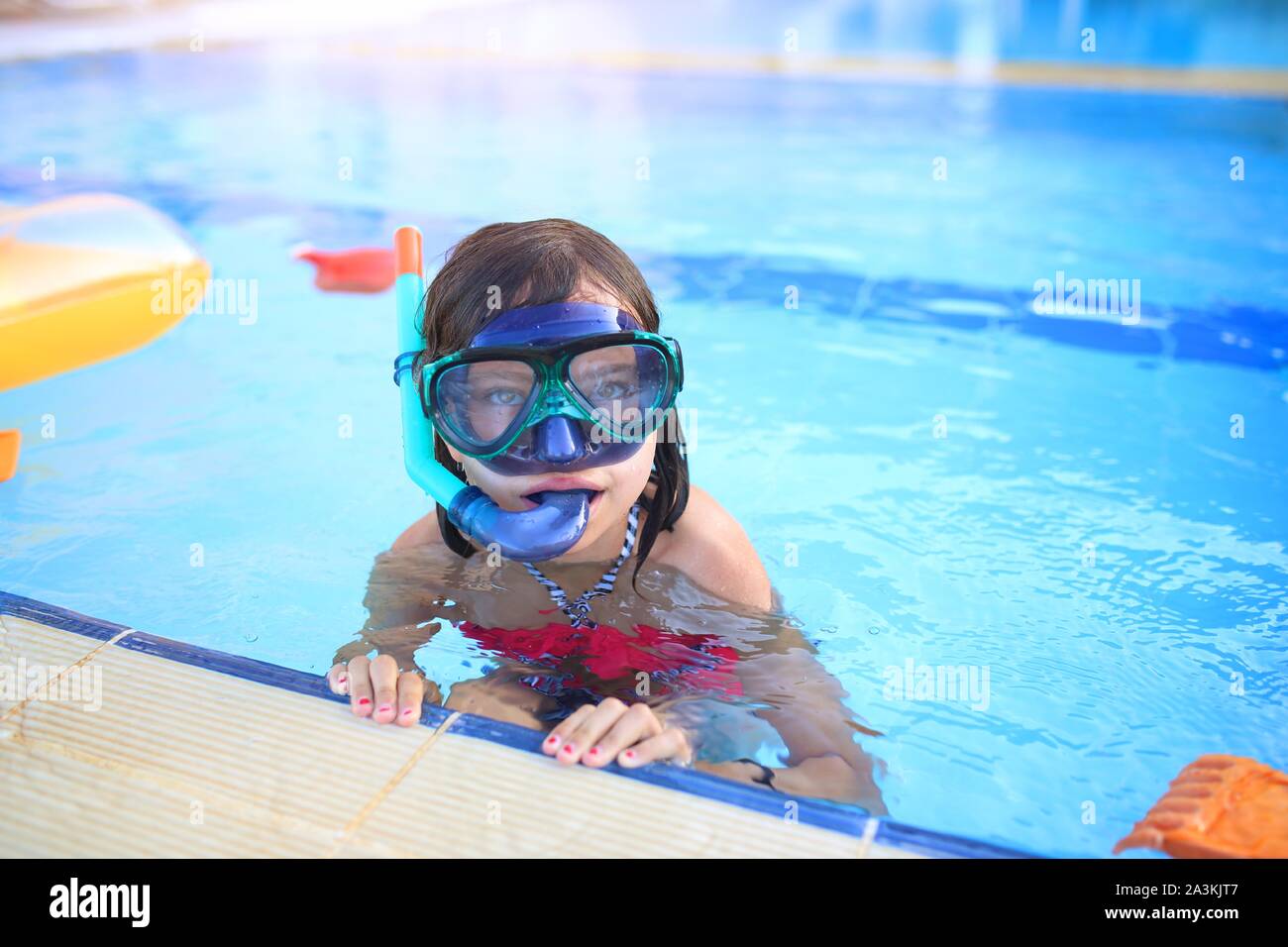 Joyful and smiling young girl in a diving mask in the pool Stock Photo