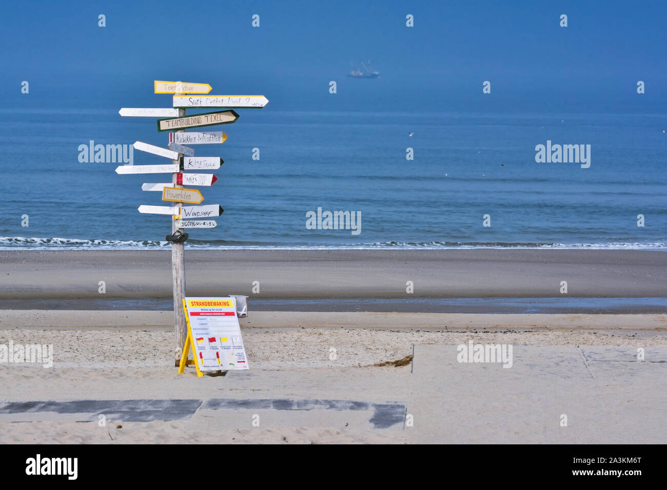 Texel / Netherlands, Big signpost with many signs with various  leisure activities written on them in Dutch on beach 'Paal 9' on island Texel Stock Photo