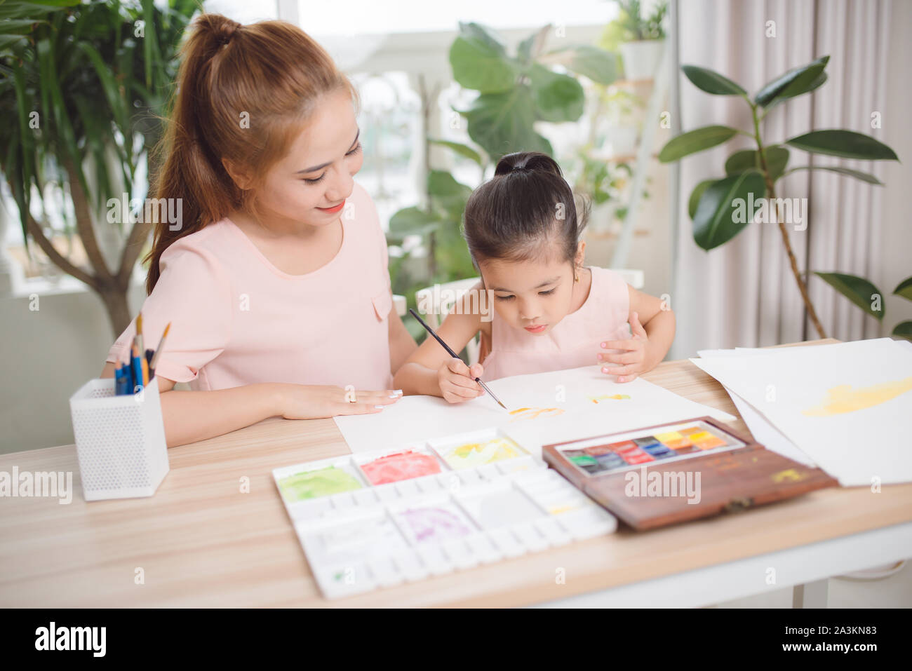 Little girl painting with her mother laying in livingroom Stock Photo ...