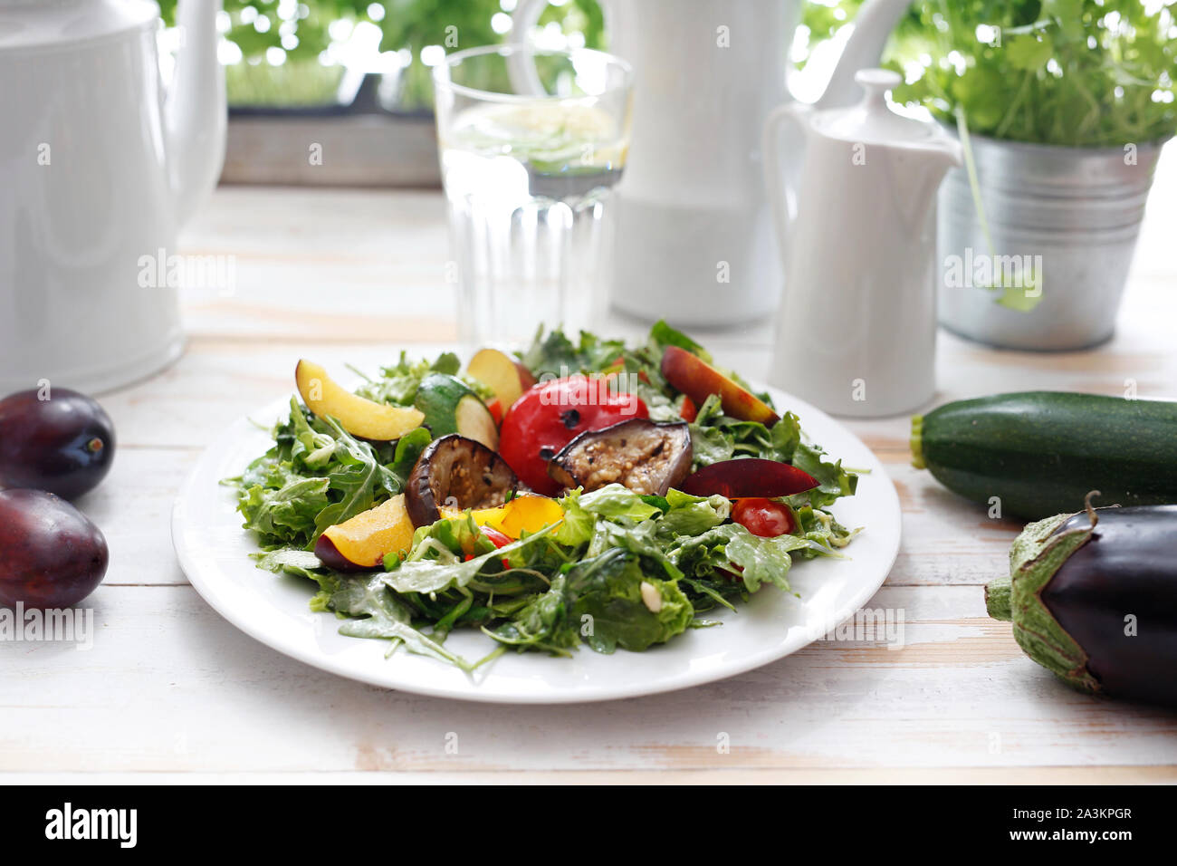 Salad of grilled vegetables on rocket salad with plum, peach and vinaigrette sauce. Stock Photo