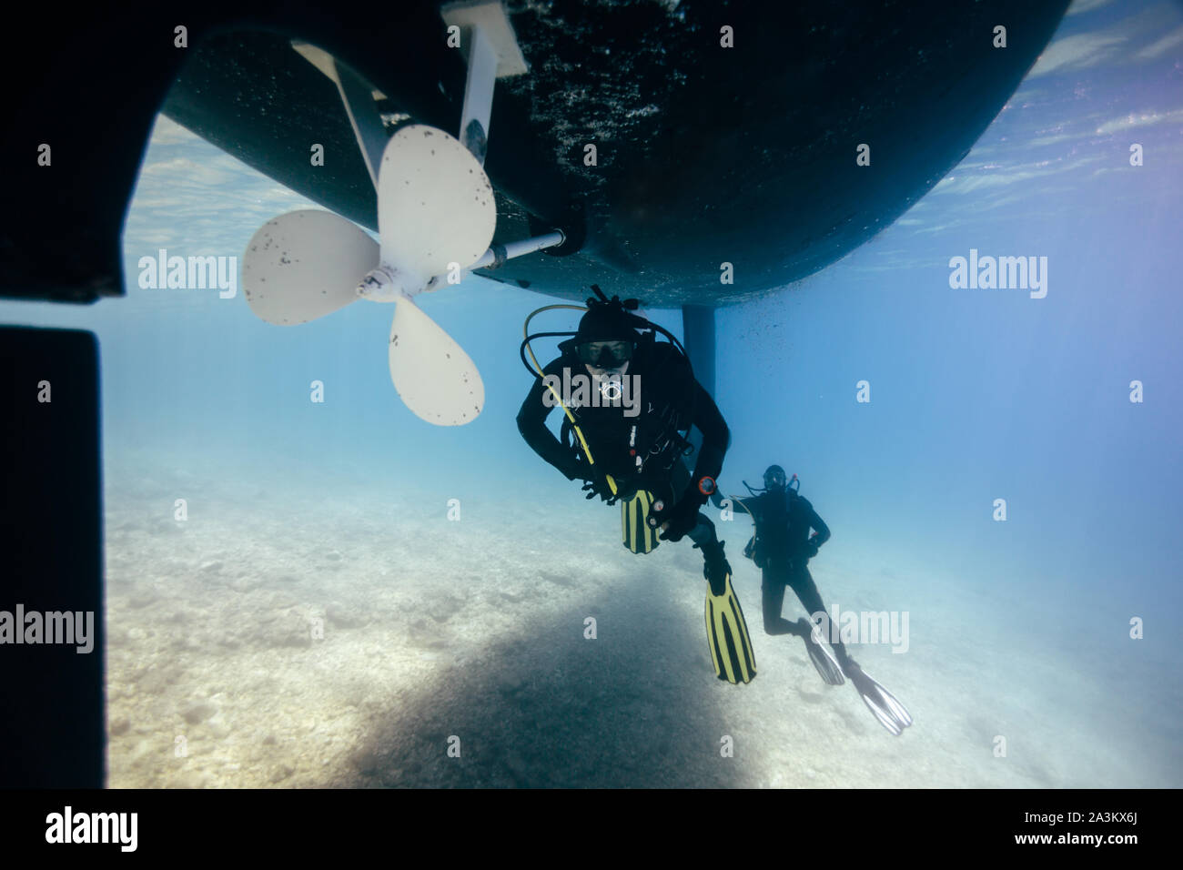 Two technical divers repairing ship propeller underwater. Technical diving. Scuba divers under