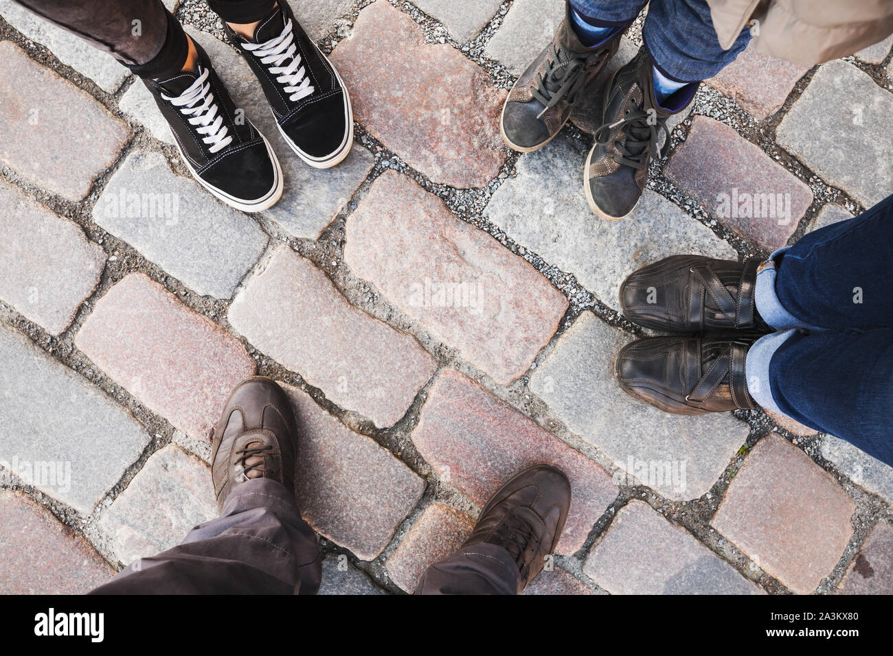 Feet of a family standing together on a paved street, top view Stock Photo