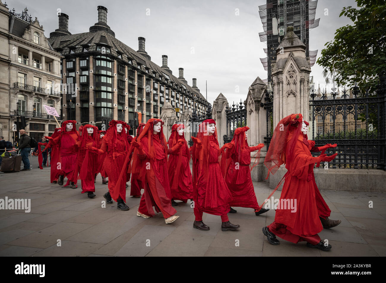Extinction Rebellion's 'Red Rebel Brigade' arrive in Westminster in their trademark blood red outfits to join the protests. The environmental campaigners begin a new wave of protest action this morning causing disruption at key sites in London, UK. Stock Photo