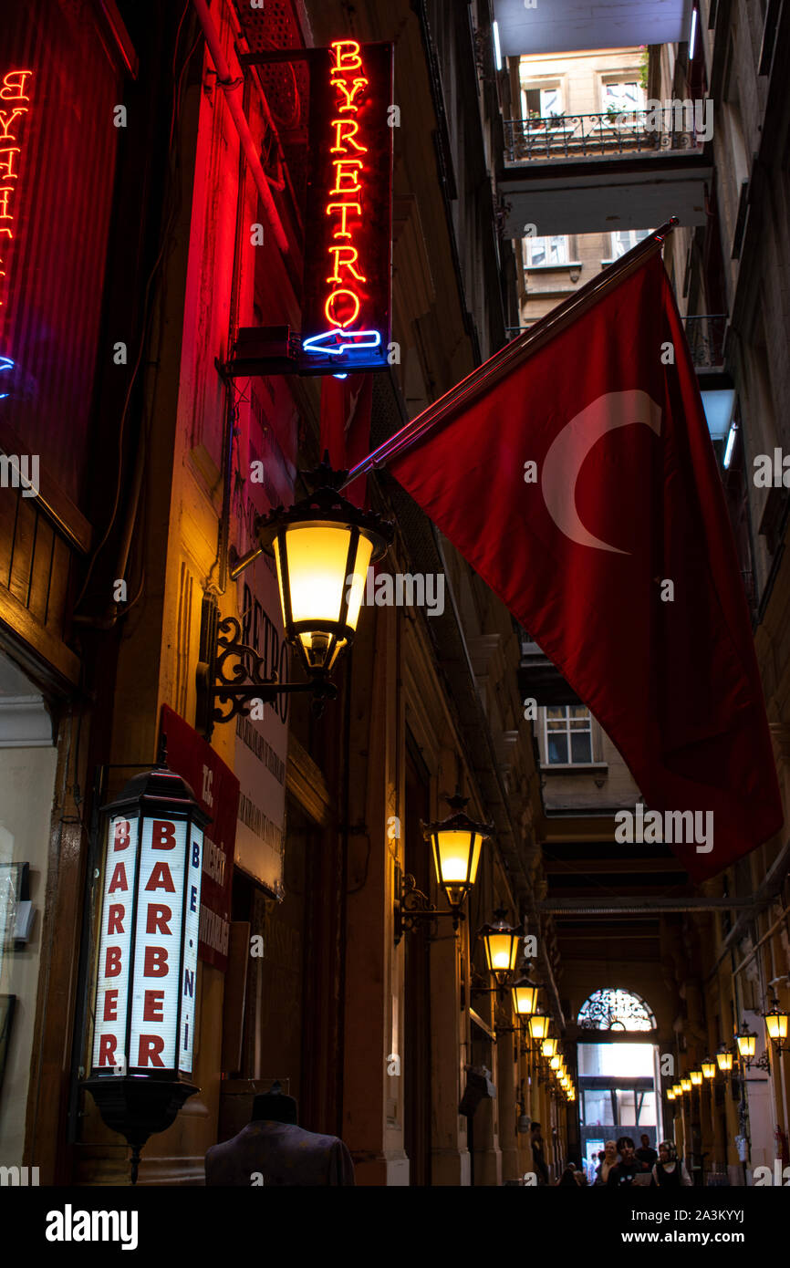 Istanbul: Turkish flag and the sign of a barber shop inside the Cicek Pasaji, the Flower Passage, historic galleria on Istiklal Caddesi, famous avenue Stock Photo